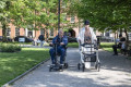 Lady walking in park with four wheeled rollator 