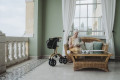 Carbon rollator folded to the side of a lady reading a book