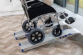 Wheelchair going up pair of folding wheelchair ramps