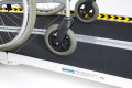 Close up of a multifold ramp with a wheelchair going up it