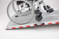 Manual wheelchair on extra wide folding wheelchair ramp