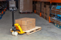 Person in warehouse pushing pallet truck 