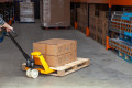 Person in warehouse pushing pallet truck 