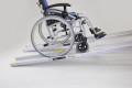 pair of telescopic wheelchair ramps with manual wheelchair going up the ramps 