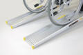 Manual wheelchair on a pair of aluminium wheelchair ramps 