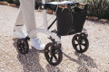Four wheeled rollator in use on a pathway
