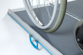 Manual wheelchair on portable wheelchair ramp with antiskid surface 