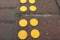 Yellow discs on bricks 