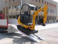JCB Digger driving down pair of aluminium loading ramps 