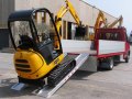 Mini digger on aluminium ramps
