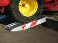 Pair of aluminium container ramps resting on kerb