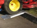 Pair of aluminium container ramps resting on kerb 