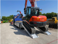 Plant machinery driving up alloy ramps onto van 