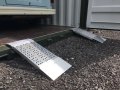 Pair of aluminium container ramps resting on container 