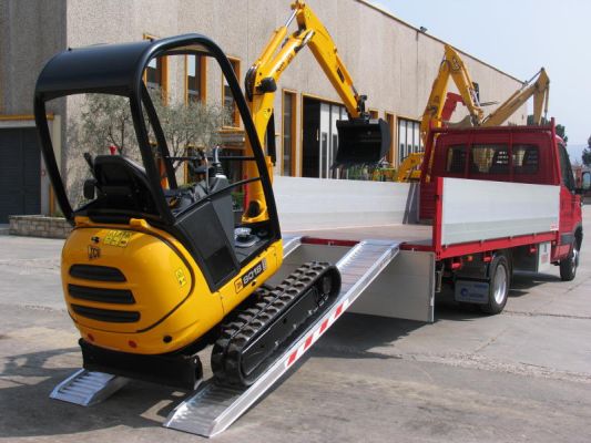 Mini digger on aluminium loading ramps 