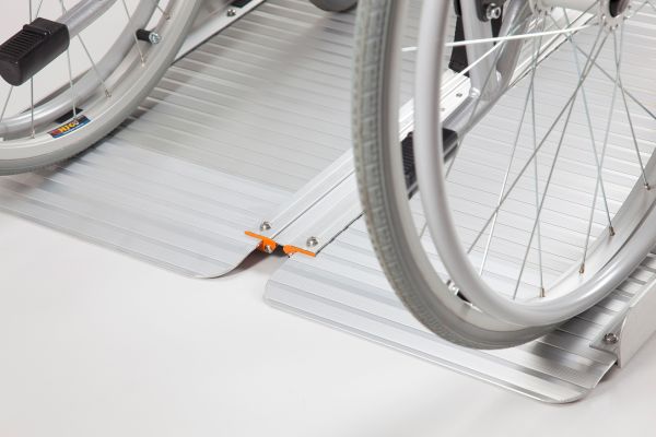 Manual wheelchair going up a portable wheelchair ramp