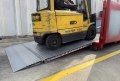 Forklift driving up aluminium container ramp