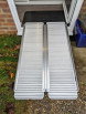 Portable folding wheelchair ramp paired with a rubber ramp inside a door to create a bridge over a door threshold