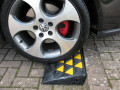 Car driving on rubber kerb ramp 