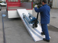 Man loading pallet truck on truck ramp