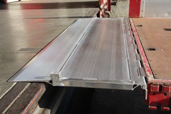 Hinged tailboard resting on ground 