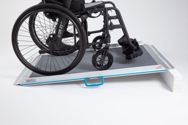 Non-folding wheelchair ramp with self propelled wheelchair going up the ramp 