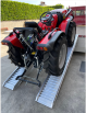 Tractor driving up ramps onto van 