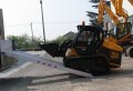 JCB driving up aluminium loading ramps 