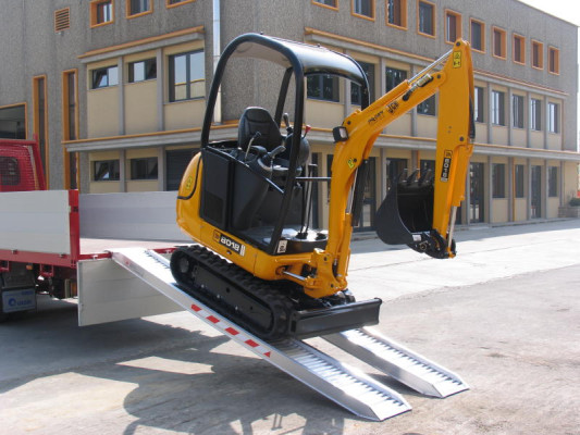 Mini digger on loading ramps 