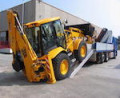 Digger driving up loading ramps 