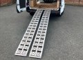 Pair of aluminium loading ramps resting on van 