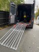 Folding extra wide motorcycle loading ramp resting on van