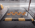 flow plates installed in place with a speed bump positioned in front to slow traffic at the entrance of a car park