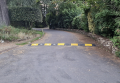 75mm high speed bumps fixed across a private road, alternatively black and yellow in colour