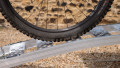 Motorcycle ramp resting on vehicle with a push bike being loaded, close up side view of the ramp