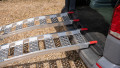 Pair of motorcycle ramps resting on vehicle, close up of grip surface and red finger style rest on connections