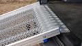 Close up of the rest on connection of a FEAL folding van ramp resting on boot of car