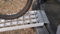 Folding extra wide motorcycle loading ramp resting on van