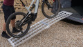 Folding extra wide motorcycle loading ramp resting on car with bike being loaded