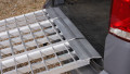 extra wide motorbike loading ramps resting on car, close up of rest on connection