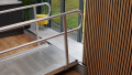 Wheelchair ramp with handrails resting on a step ready for use