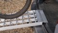 Folding extra wide motorcycle loading ramp resting on van