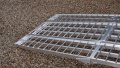 extra wide motorbike loading ramps resting on car, close up of foot end