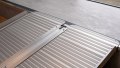 economy folding ramp resting on step, close up of rest on connection. Anti-slip aluminium surface