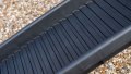 Close up of the grip surface of a black folding dog ramp resting on the boot of a car