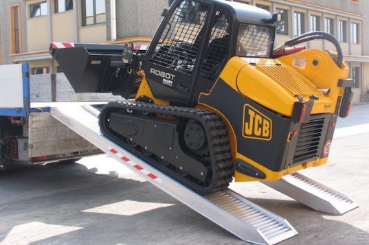 JCB driving up heavy duty aluminium loading ramps 