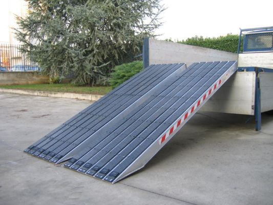 Rubber tracked loading ramps resting on vehicle 