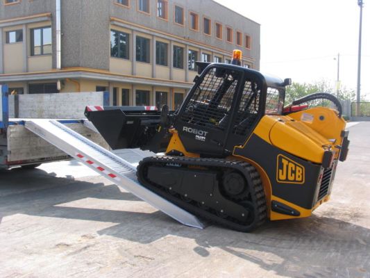 Plant machine driving on to loading ramps 