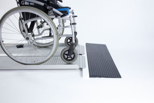 Manual wheelchair going up ramp onto threshold 