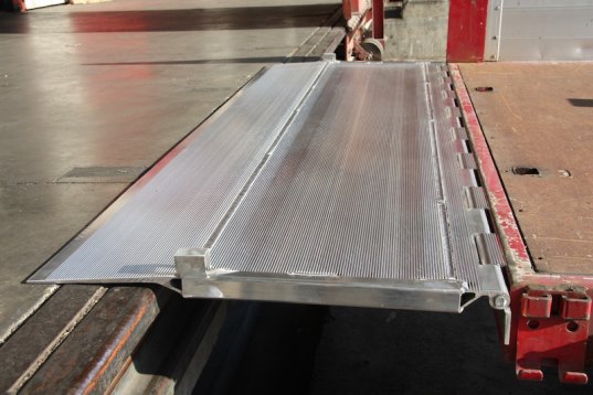 Hinged tailboard resting on ground 